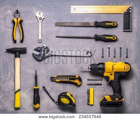 A Set Of Yellow Hand Tool On A Gray Background. Top View.