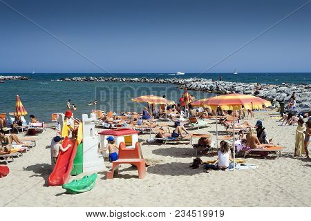 Sanremo, Liguria, Italy - May 23, 2009: Families Relaxing On A Mediterranean Beach In Sanremo Italy 