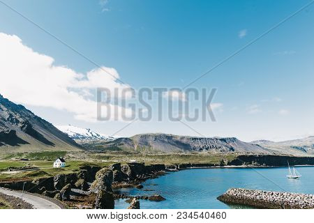 Gatklettur, Arnastapi, Iceland - 20 July, 2016: Beautiful Seaside With Floating Yacht On Water, Road