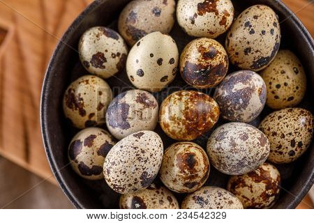 Quail Eggs In A Black Cup Close-up. A Lot Of Quail Eggs In A Cup.