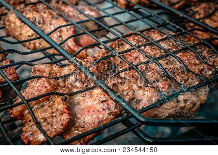 Large Pieces Of Pork Are Fried On The Grill.