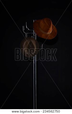 Hats Hanging On Coat Rack Isolated On Black