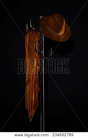 Scarf And Hat Hanging On Coat Rack Isolated On Black