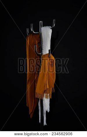 Various Scarves Hanging On Coat Rack Isolated On Black