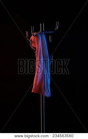 Cloth Hanging On Coat Rack Under Toned Light Isolated On Black