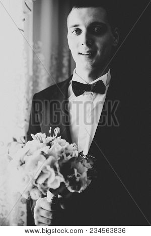 Happy Handsome Smiling Groom Posing With Boutonniere.