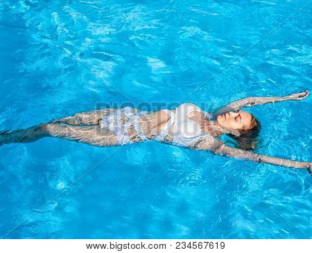 Beautiful Girl Swimming On Back In Water