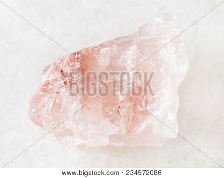 Macro Shooting Of Natural Mineral Rock Specimen - Rough Crystal Of Rose Quartz Gemstone On White Mar