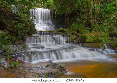 Mun Dang Waterfall With A Pink Flower Foreground In Rain Forest At Phitsanulok Province, Thailand