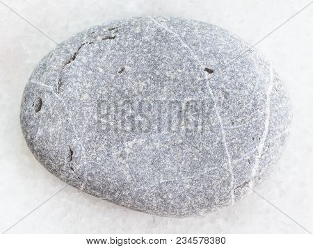Macro Shooting Of Natural Mineral Rock Specimen - Tumbled Greywacke Sandstone On White Marble Backgr