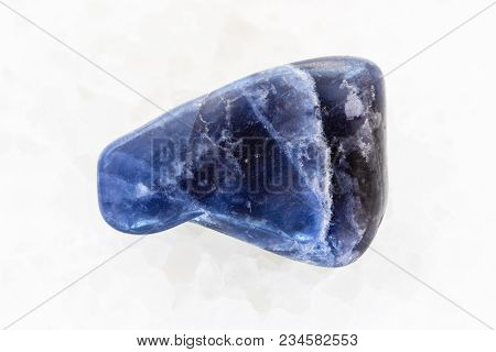 Macro Shooting Of Natural Mineral Rock Specimen - Tumbled Dumortierite Gemstone On White Marble Back