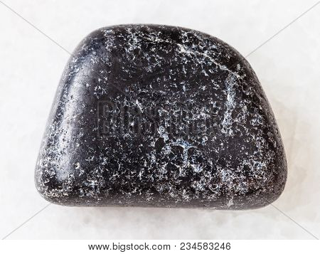 Macro Shooting Of Natural Mineral Rock Specimen - Polished Chromite Stone On White Marble Background