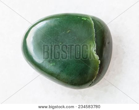 Macro Shooting Of Natural Mineral Rock Specimen - Pebble Of Green Nephrite Gemstone On White Marble 