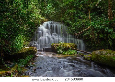 Mun Dang Waterfall With A Pink Flower Foreground In Rain Forest At Phitsanulok Province, Thailand