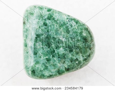 Macro Shooting Of Natural Mineral Rock Specimen - Tumbled Green Jadeite Gemstone On White Marble Bac