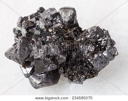 Macro Shooting Of Natural Mineral Rock Specimen - Rough Crystalline Magnetite Stone On White Marble 