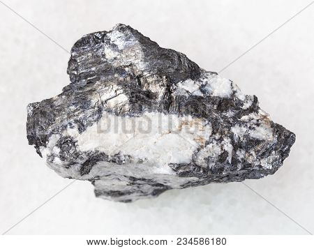 Macro Shooting Of Natural Mineral Rock Specimen - Bismuthinite Vein In Raw Quartz Stone On White Mar