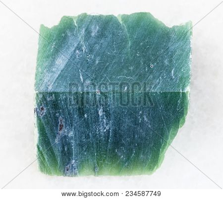 Macro Shooting Of Natural Mineral Rock Specimen - Raw Nephrite Stone Slab On White Marble Background