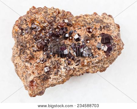 Macro Shooting Of Natural Mineral Rock Specimen - Andradite Garnet Crystals On Stone On White Marble