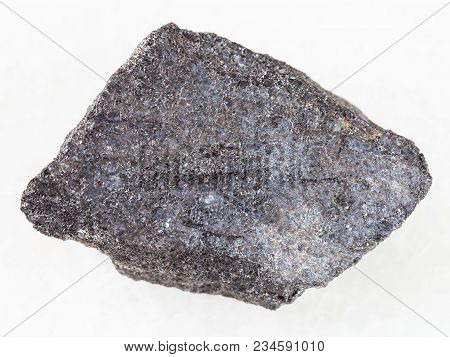 Macro Shooting Of Natural Mineral Rock Specimen - Raw Chromite Stone On White Marble Background From