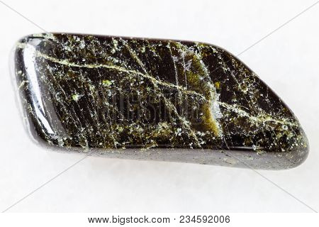 Macro Shooting Of Natural Mineral Rock Specimen - Tumbled Diopside Gemstone On White Marble Backgrou