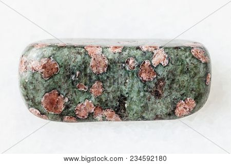 Macro Shooting Of Natural Mineral Rock Specimen - Tumbled Eclogite Gemstone On White Marble Backgrou