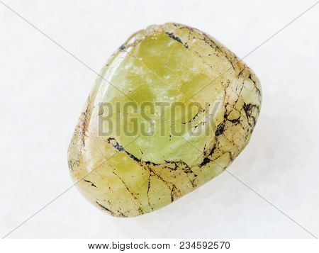 Macro Shooting Of Natural Mineral Rock Specimen - Tumbled Green Beryl Gem Stone On White Marble Back