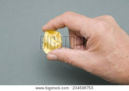 A Tortellino Pasta Between The Fingers Of The Hand
