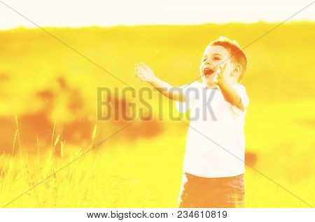happy young beautiful child have fun on eadow with soap bubbles toy