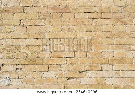 Textured Background Of A Stone Brick Of Yellow Antediluvian Masonry. Partially Destroyed Wall. Brick