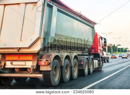 Big Dump Truck Goes In The Evening On Highway