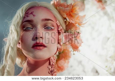 Young Beautiful Girl. Attractive Elf Close-up. Creative Pink Makeup. Hairstyle With Flowers.