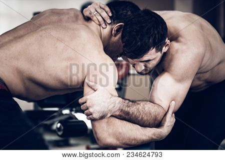 Two Strong Men Without Shirts Wrestling In Gym