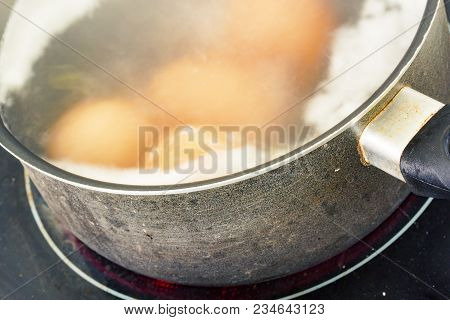 Closeup On Cooking Eggs In A Pot Of Water On A Ceramic Hob