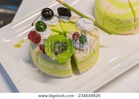 Pistachio Cake Sliced On White Wooden Background.
