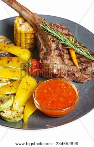 Grilled Meat On Bone With Garnish Of Vegetables