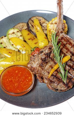 Grilled Meat On Bone With Garnish Of Vegetables