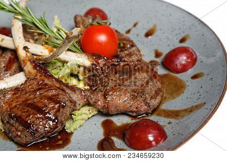 Fried Meat With Garnish Of Pepper, Zucchini, Tomato And Corn With Ajika Sauce Served On A Gray Plate