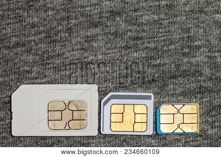 Set Of Mini, Micro And Nano Simcard. Isolated On Grey Cloth Texture Background
