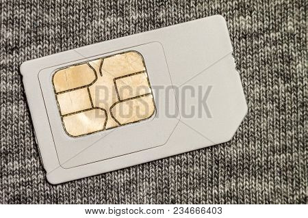 Simcard Isolated On Grey Cloth Texture Background