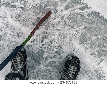 Top Down View Of Hockey Puck And Skates On Ice