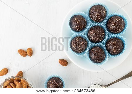 Chocolate Energy Bites With Nuts, Cocoa Powder, Dates And Coconut Flakes. Top View With Copy Space.