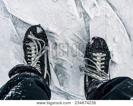 Top Down View Of Hockey Puck And Skates On Ice