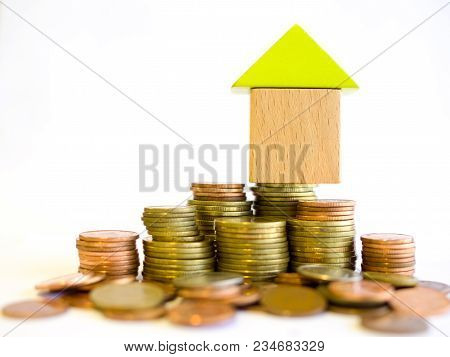 Coins And Blocks - Small Blocks House Standing On A Pile Of Coins. The Concept Of Purchase Of Habita