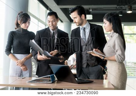 Smart Manager Explaining Internal Meeting To His Project Team In Modern Office. The Multi Ethnic Bus