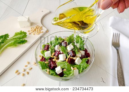 Salad Of Beetroot, Feta Cheese And Lettuce Leaves With Pine Nuts Poured With Olive Oil White Wooden 