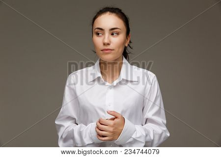 Beautiful Girl In A White Shirt Shows Emotions. On A Light Background.