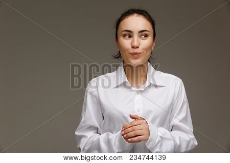 Beautiful Girl In A White Shirt Shows Emotions. On A Light Background.