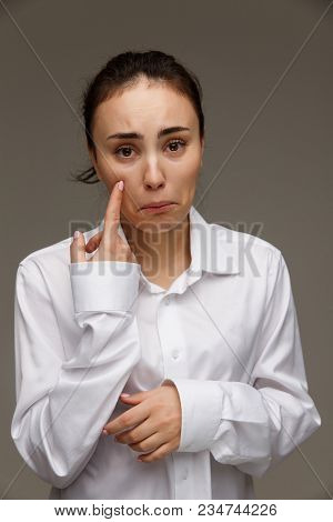 Beautiful Girl In A White Shirt Shows Emotions. On A Light Background.