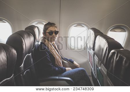 Asian Single Woman On Passenger Seat Of Airplane